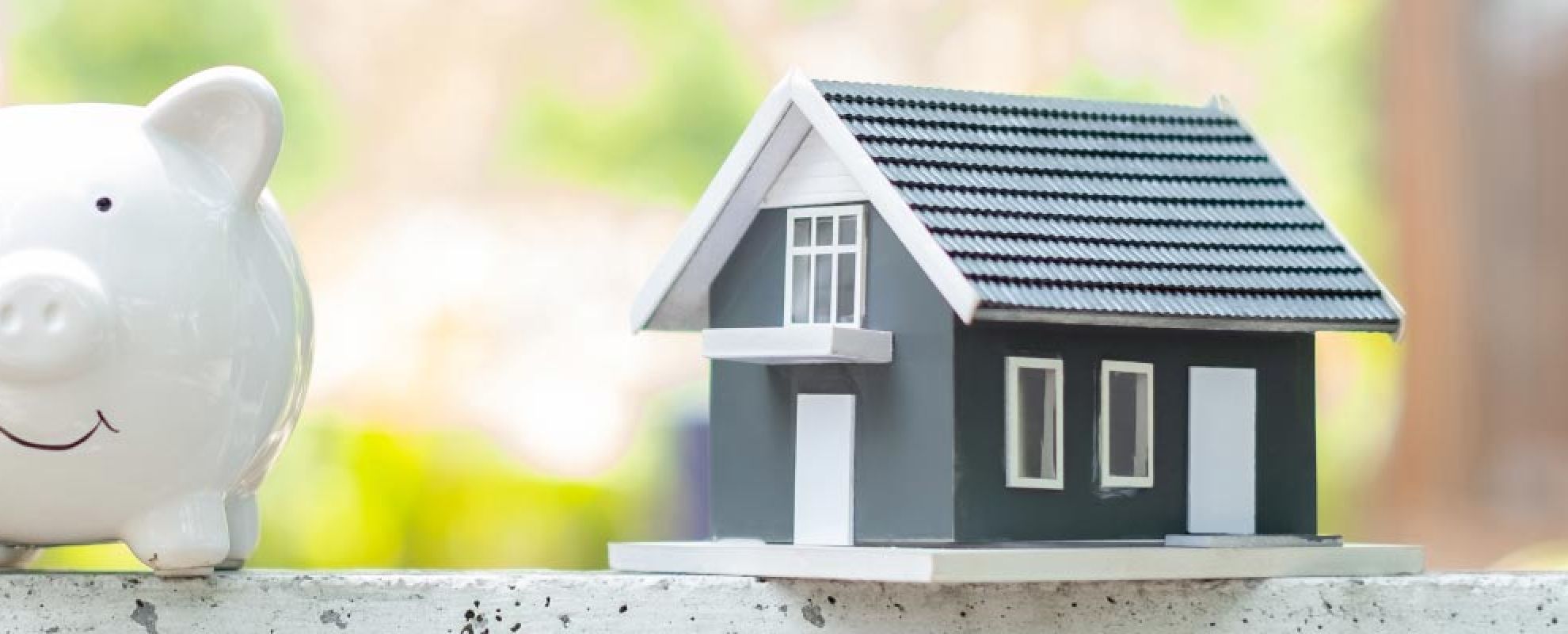 Visuel d'une tirelire en forme de cochon et d'une petite maison pour symboliser l'emprunt immobilier.